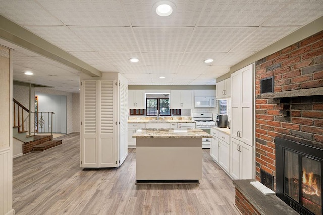 51 Strong Rd, Ferndale, NY 12734 - kitchen featuring a sink, a fireplace, a kitchen island, and white cabinetry