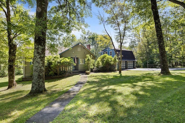 51 Strong Rd, Ferndale, NY 12734 - view of front facade featuring a chimney, an outbuilding, a front yard, and a garage