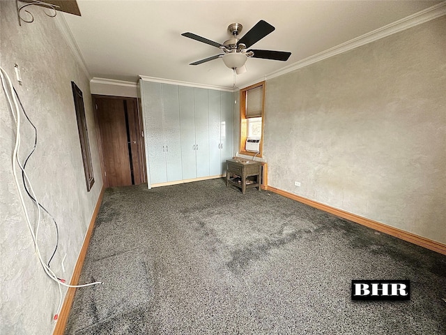 unfurnished bedroom with ornamental molding, carpet flooring, a textured wall, baseboards, and a ceiling fan