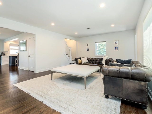 living area featuring plenty of natural light, stairs, dark wood-style floors, recessed lighting, and baseboards