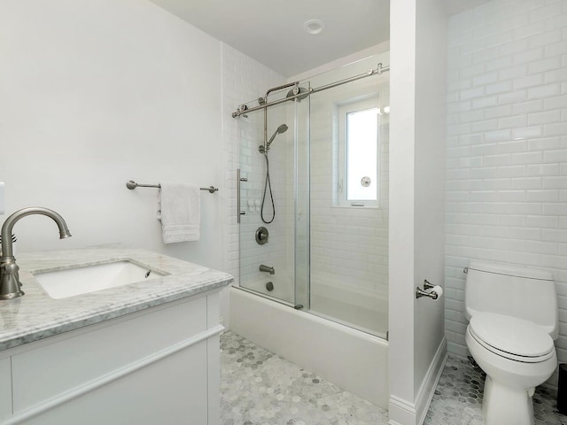 bathroom with toilet, bath / shower combo with glass door, and vanity