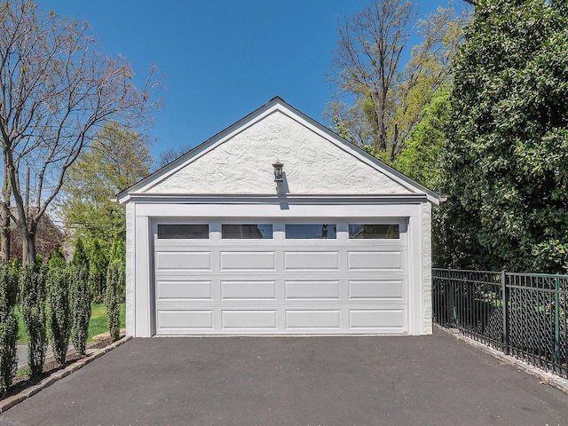 detached garage featuring fence