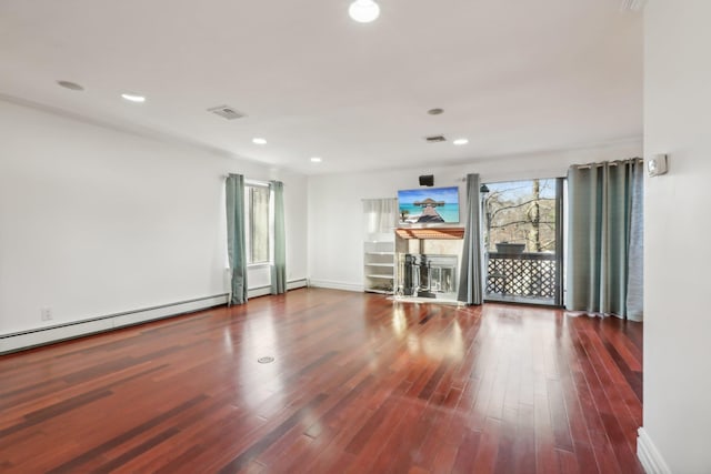 empty room featuring recessed lighting, a baseboard radiator, wood finished floors, and visible vents