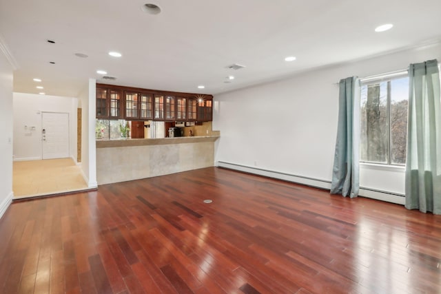 unfurnished living room with visible vents, a baseboard radiator, wood finished floors, and recessed lighting
