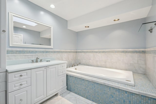 full bathroom featuring vanity, a garden tub, and tile walls