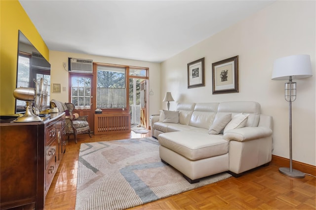 living room with baseboards, a wall unit AC, and radiator