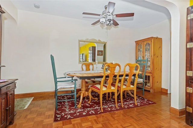 dining space with baseboards and ceiling fan