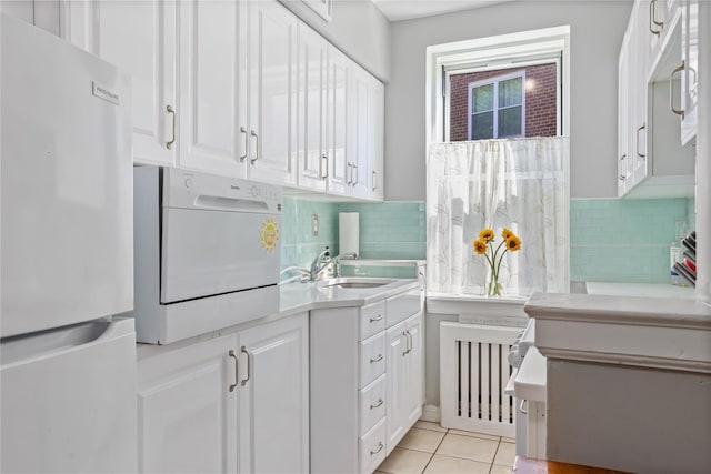 bathroom featuring a sink, tile patterned floors, radiator heating unit, washer / clothes dryer, and tasteful backsplash