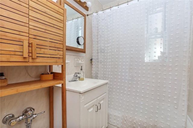 full bath featuring a shower with curtain, tile walls, and vanity