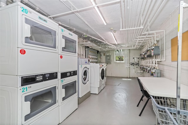 community laundry room featuring stacked washer / drying machine and washing machine and clothes dryer