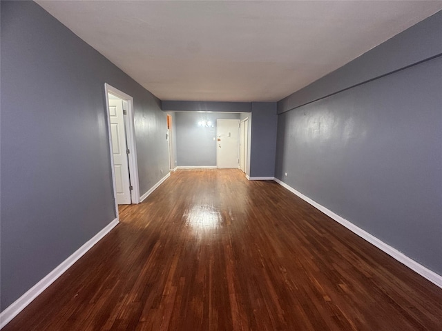 corridor featuring wood finished floors and baseboards