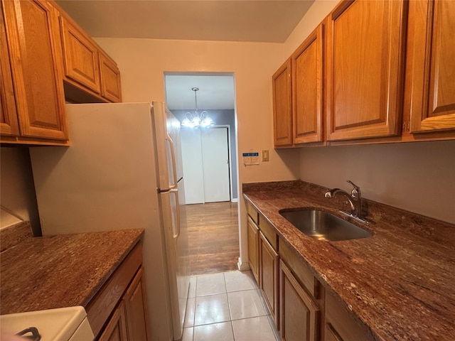 kitchen featuring a sink, brown cabinets, and dark stone counters