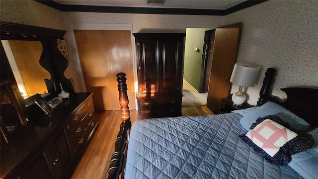 bedroom featuring wallpapered walls, visible vents, and wood finished floors