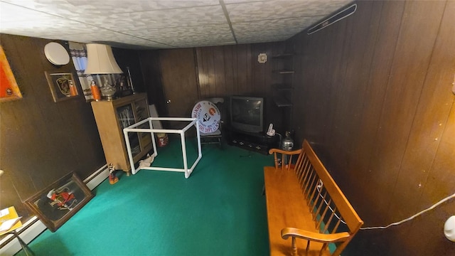 playroom with carpet flooring, a baseboard heating unit, and wood walls