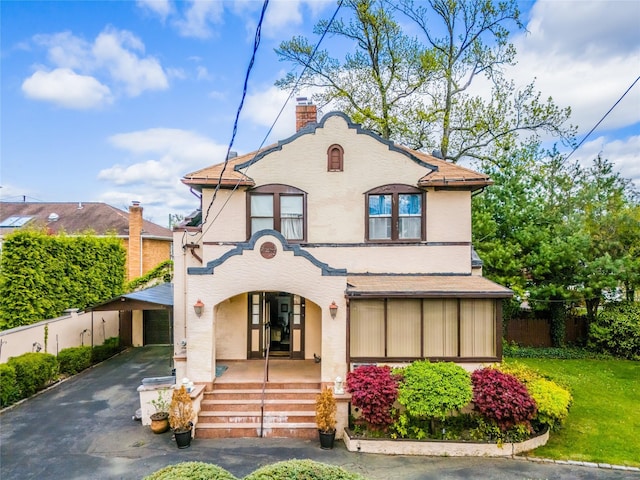 14-35 161st St, Beechhurst, NY 11357 - view of front facade featuring a porch, a front yard, a chimney, stucco siding, and fence