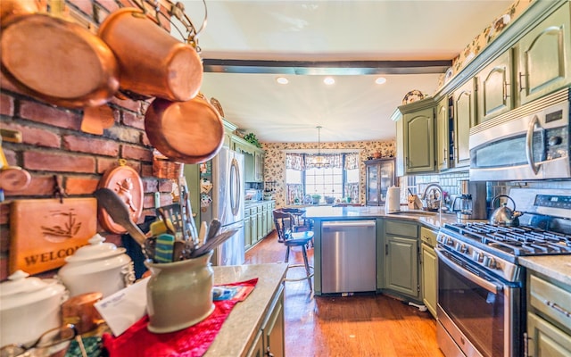14-35 161st St, Beechhurst, NY 11357 - kitchen featuring recessed lighting, green cabinetry, wallpapered walls, appliances with stainless steel finishes, and a peninsula