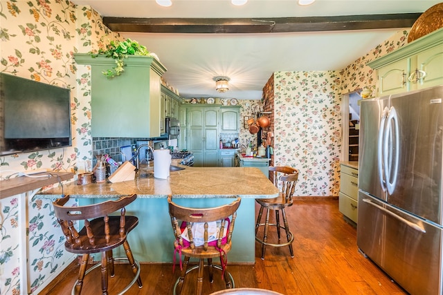 14-35 161st St, Beechhurst, NY 11357 - kitchen featuring green cabinetry, appliances with stainless steel finishes, wallpapered walls, dark wood-style flooring, and a peninsula