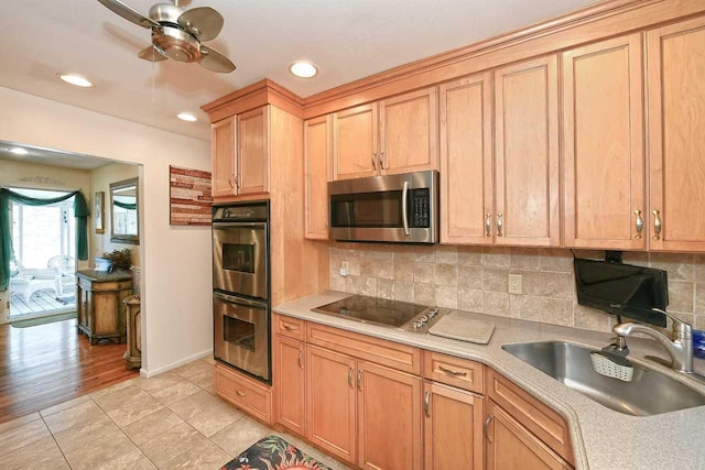 kitchen with light countertops, a sink, decorative backsplash, and stainless steel appliances