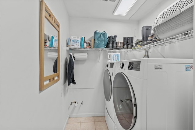 laundry room featuring laundry area, baseboards, light tile patterned floors, visible vents, and washing machine and dryer