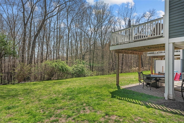view of yard with a patio, outdoor dining space, and a deck
