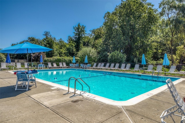 pool featuring fence and a patio