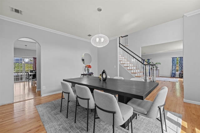 3 Kings Dr, Middletown, NY 10941 - dining space featuring arched walkways, stairs, a chandelier, ornamental molding, and light wood-style floors