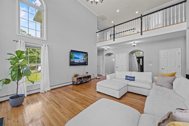 3 Kings Dr, Middletown, NY 10941 - living area with arched walkways, a high ceiling, wood finished floors, a baseboard heating unit, and baseboards