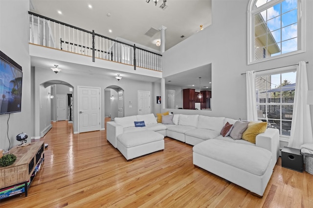 3 Kings Dr, Middletown, NY 10941 - living room with arched walkways, a high ceiling, and light wood finished floors