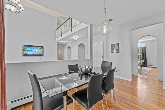 3 Kings Dr, Middletown, NY 10941 - dining area with arched walkways, wood finished floors, baseboards, and a baseboard heating unit