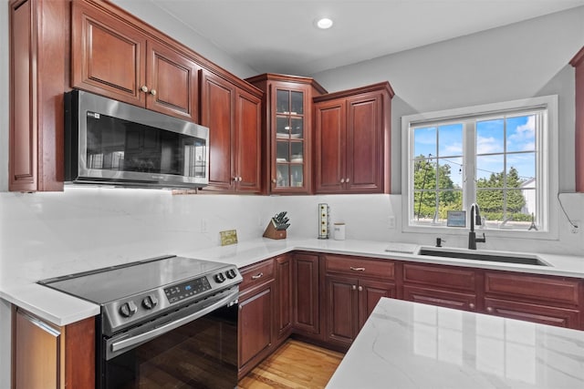 3 Kings Dr, Middletown, NY 10941 - kitchen featuring stainless steel appliances, a sink, glass insert cabinets, light stone counters, and recessed lighting