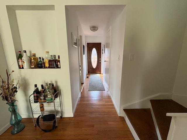 hallway with wood finished floors and baseboards
