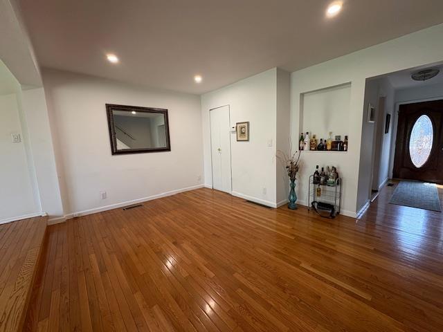 foyer featuring baseboards, visible vents, and hardwood / wood-style flooring