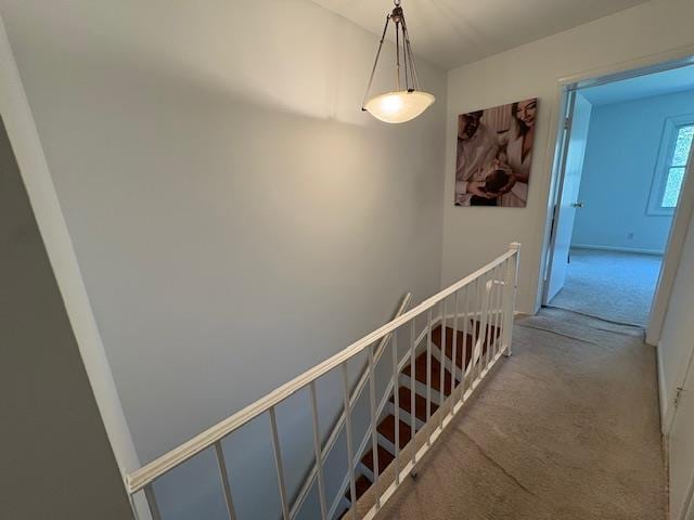 hallway with an upstairs landing and carpet floors