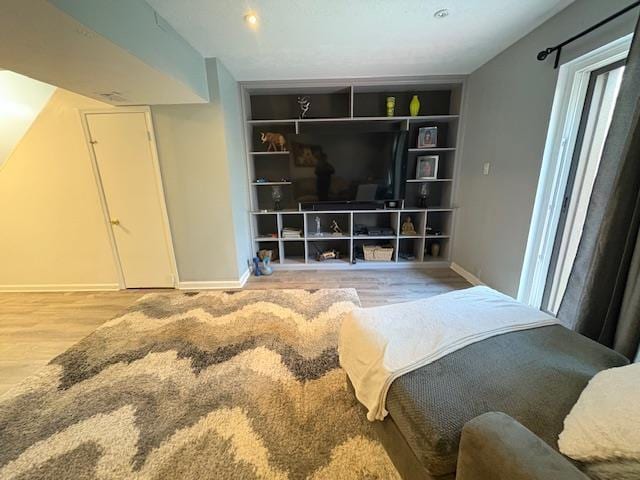bedroom featuring wood finished floors and baseboards