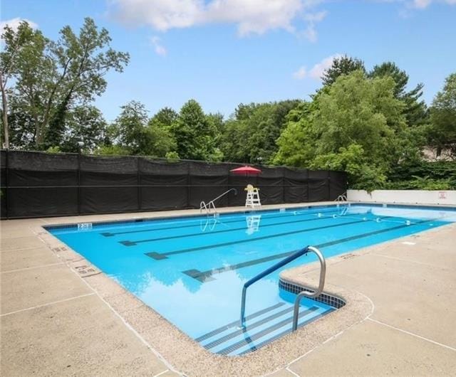 community pool with fence and a patio area
