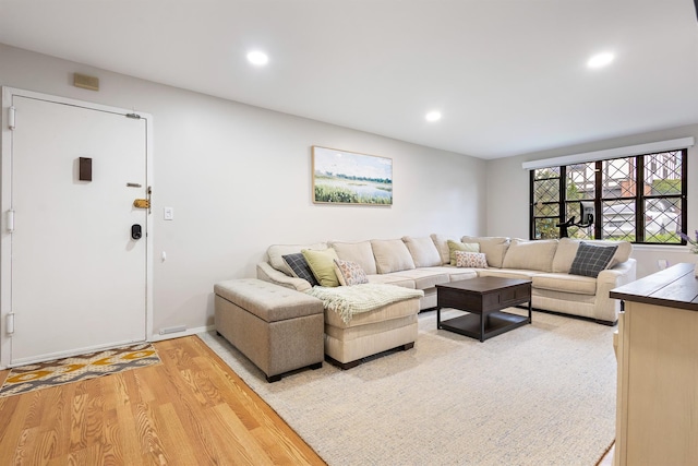 living area with recessed lighting, baseboards, and light wood-style flooring