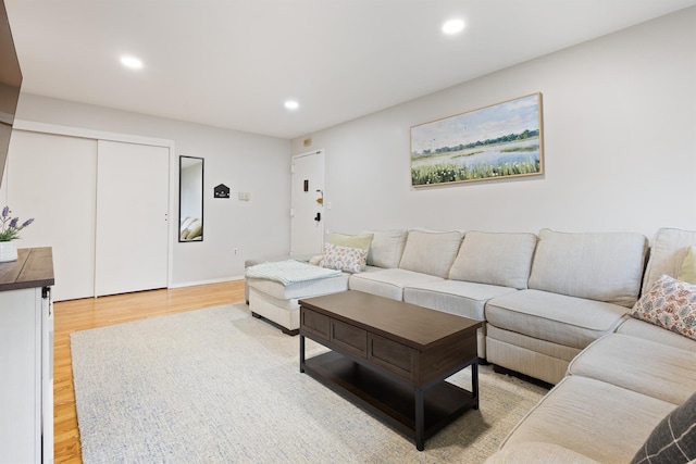 living room featuring baseboards, recessed lighting, and light wood-style flooring