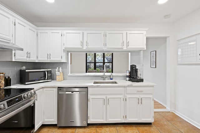 kitchen with a sink, decorative backsplash, stainless steel appliances, and white cabinetry