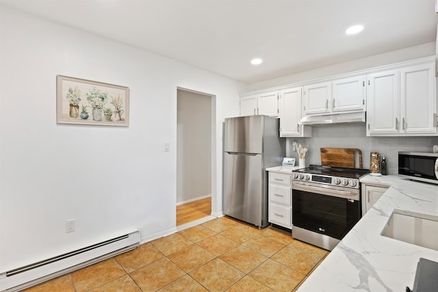 kitchen featuring white cabinets, light stone countertops, appliances with stainless steel finishes, under cabinet range hood, and a baseboard heating unit