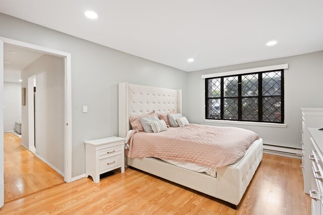 bedroom with light wood-style floors, recessed lighting, and baseboard heating
