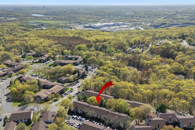 drone / aerial view featuring a residential view and a wooded view