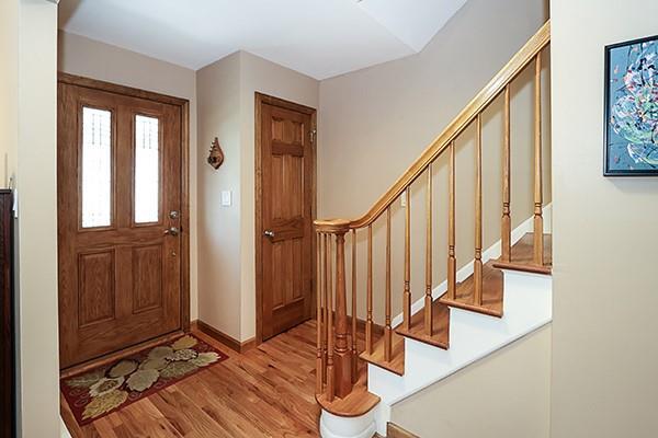 foyer with baseboards, stairs, and wood finished floors