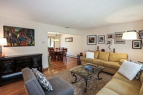 living area featuring a textured ceiling, baseboard heating, and wood finished floors