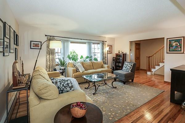living area with stairway and wood finished floors