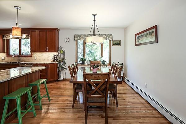 dining space featuring a baseboard radiator and wood finished floors