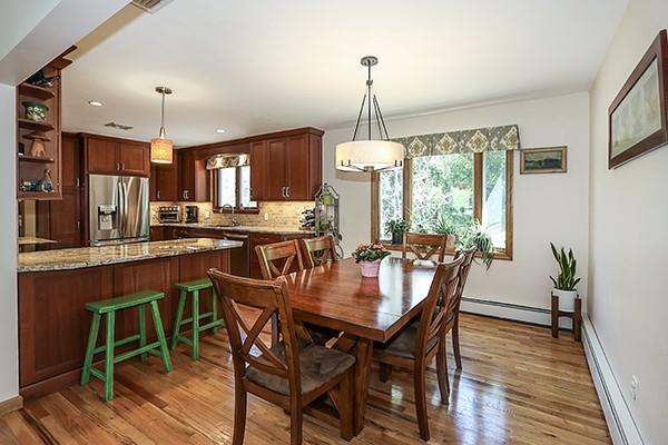 dining room featuring baseboards, a baseboard radiator, and wood finished floors