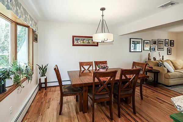 dining area with visible vents, baseboard heating, and wood finished floors