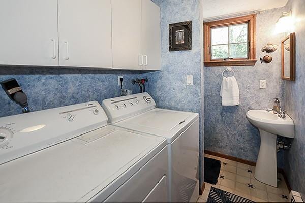 laundry room with laundry area, a sink, tile patterned flooring, a baseboard heating unit, and washing machine and dryer