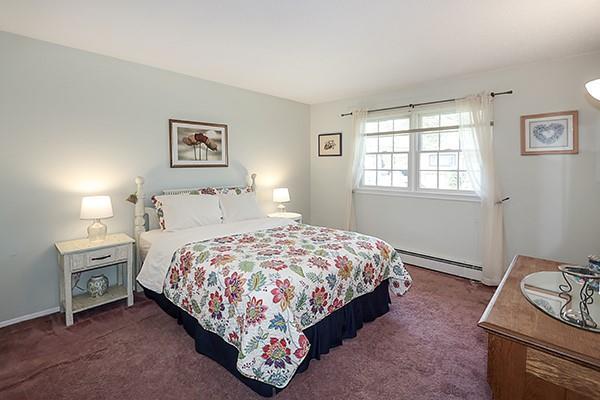bedroom featuring baseboard heating and dark carpet