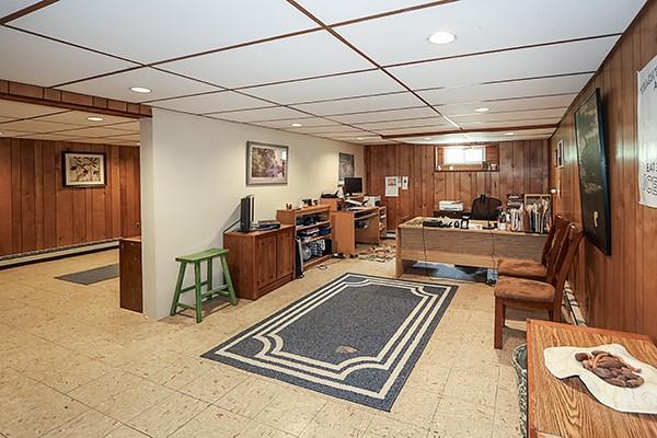 office area with wood walls, tile patterned floors, and baseboard heating